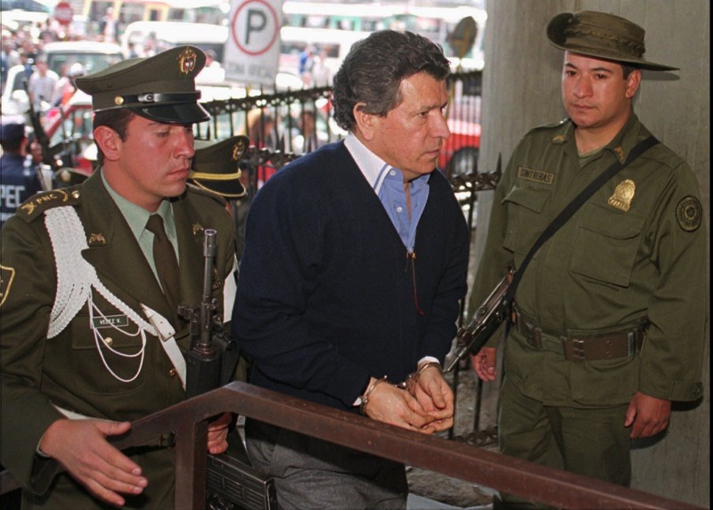 Мигель Родригес Орехуэло, один из лидеров наркокартеля Кали, в окружении колумбийских полицейских в федеральной прокуратуре в Боготе, Колумбия. Сентябрь 1996 года