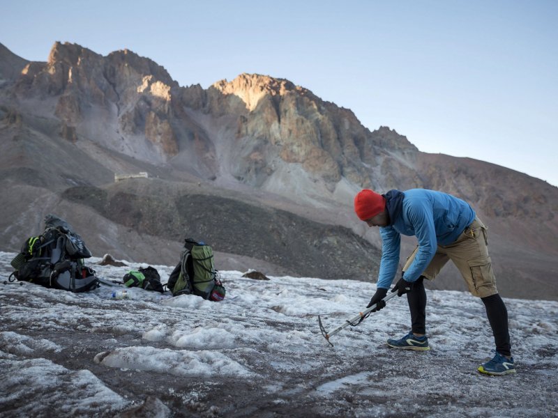 Венгерский альпинист Нандор Терек готовится устанавливать палатку на леднике по пути к вершине горы Казбек, 13 сентября 2017 года.