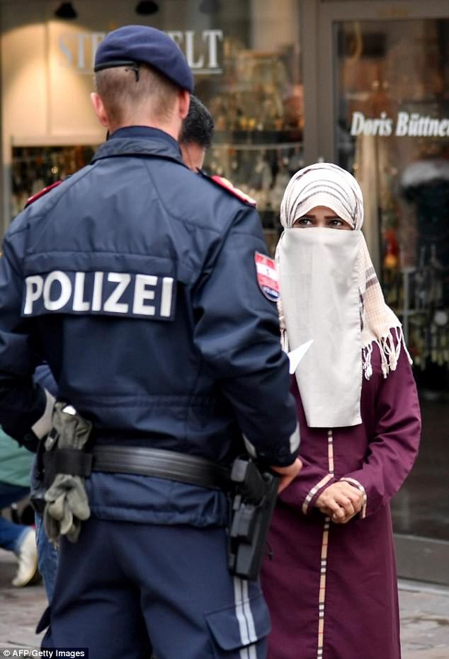 На фото: в день вступления ограничения в силу полиция отлавливала нарушителей на улицах. Мусульманская женщина была вынуждена открыть лицо.