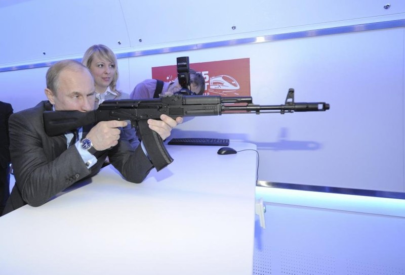Путин целится из модели Ак-47 на стрельбище во время визита в офис РЖД, апрель 2012 года.