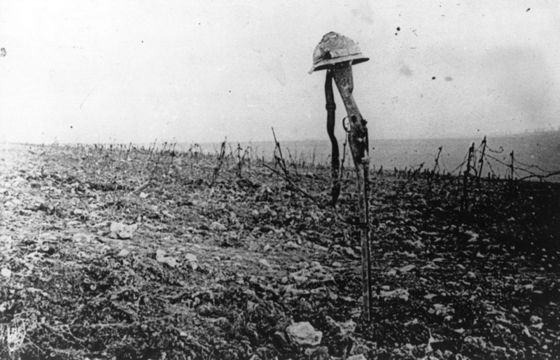 Могила на поле боя, отмеченная винтовкой и шлемом французского солдата, под Верденем 