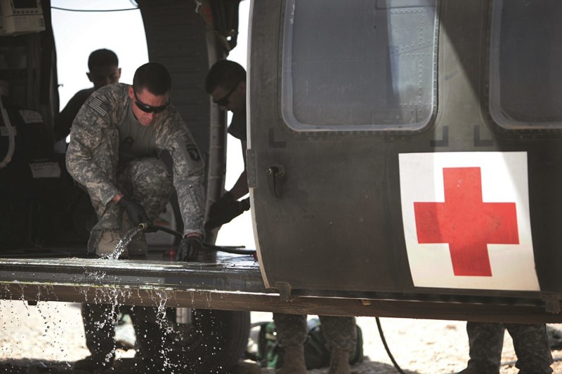 Экипаж вертолета отмывает его после перевозки раненых
