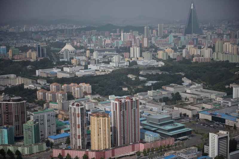 Вид на город. На заднем плане возвышается 330-метровая пхеньянская гостиница Рюгён — амбициозный проект, начатый во второй половине 1980-х годов и приостановленный в 1993-м из-за экономических проблем страны