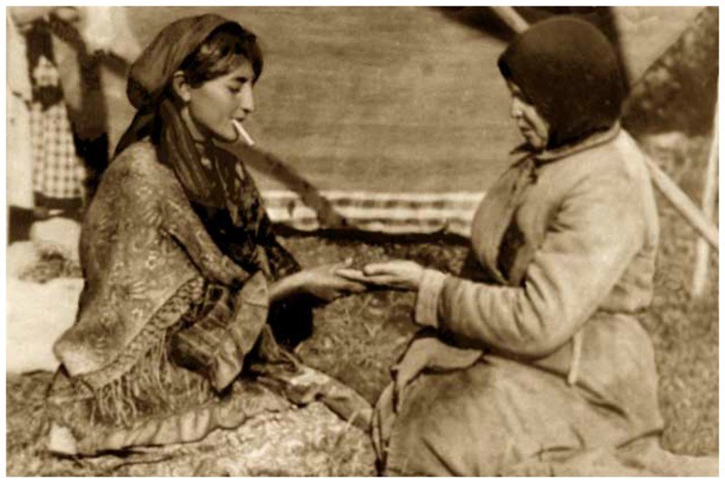 Русская таборная цыганка гадает деревенской женщине возле своего шатра. 1927 год.