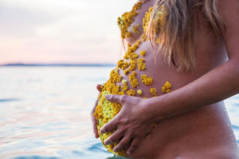 Фотограф украшает грудь и живот своей беременной девушки лепестками цветов и это прекрасно