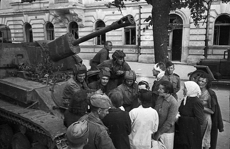 Экипаж советской САУ СУ-76М и пехотинцы общаются с жителями освобожденного советского города.