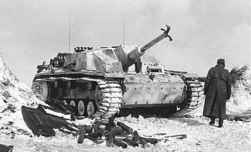 Солдат вермахта у поврежденной САУ StuG III Ausf. G (выпущенной заводом Alkett в период декабрь 1942 – январь 1943) 904-го батальона штурмовых орудий (Sturmgeschütz-Abteilung 904) в районе Курска. На машине установлены гусеницы с зимними траками