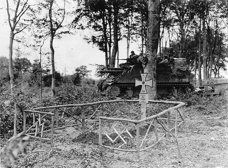 АУ М7 «Прист» 83-й пехотной дивизии армии США у могилы унтершарфюрера 17-й дивизии СС «Гетц фон Берлихинген».