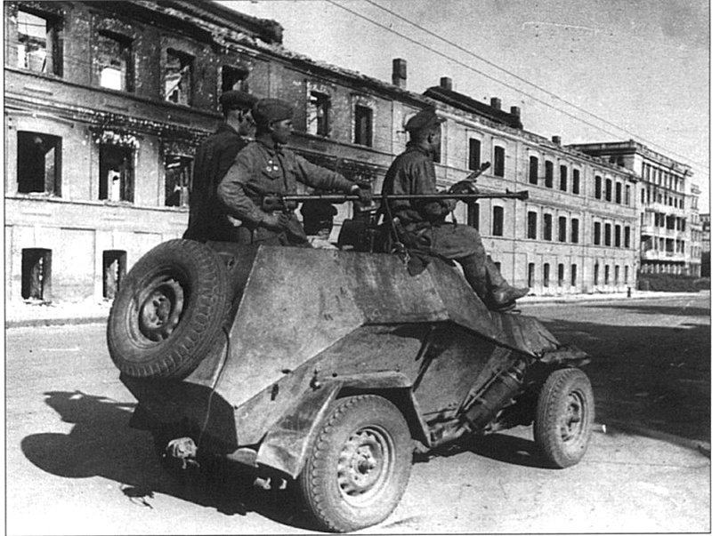 Советский бронеавтомобиль БА-64 с солдатами. В полевых условиях с бронеавтомобиля демонтирована башня и установлено противотанковое ружье.
