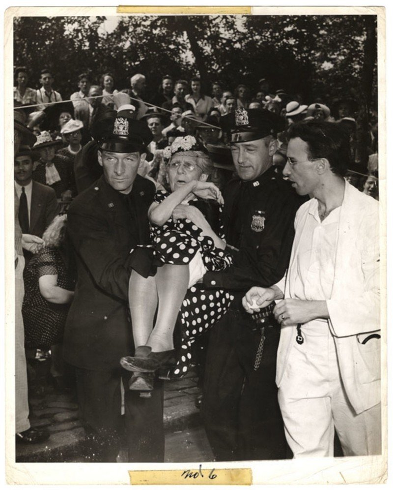 Во время военного парада на Пятой авеню леди упала в обморок от жары, 21 июня 1942 года.