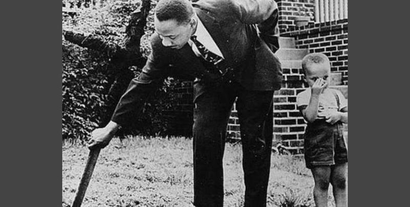 Мартин Лютер Кинг убирает сгоревший крест со своего двора, 1960 год.