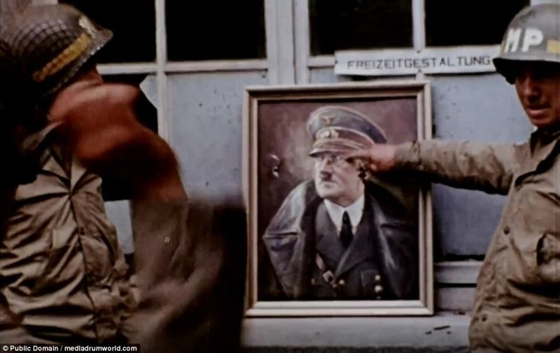 Далее - американские солдаты используют портрет Гитлера для игры в дартс