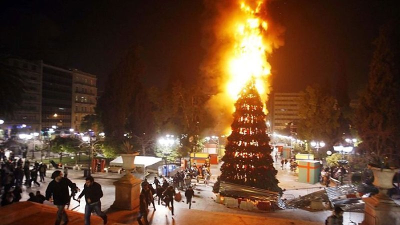 Еще елки горят - умышленно их поджигают в городе Афины, Греция. Греческие радикалы в знак протеста сожгли главную елку в 2008 году