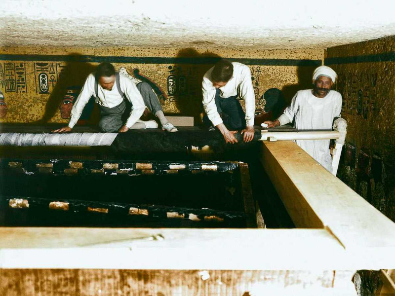  Картер, Мейс и египетский рабочий бережно сворачивают льняной покров. (1923 г.)
