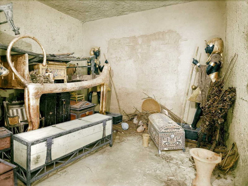 Позолоченное ложе-лев и другие объекты в прихожей. Стена погребального покоя охраняется черными статуями Ка. (1922 г.)