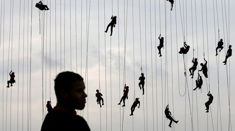 Люди возвращаются по веревкам на мост после массового прыжка в муниципалите Ортоландия, Бразилия, октябрь 2017 года