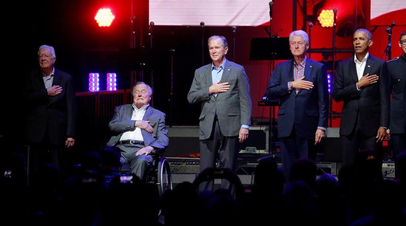Джимми Картер, Джордж Буш-старший, Билл Клинтон, Джордж Буш-младший и Барак Обама на сцене — все пять ныне живущих бывших американских президентов на мероприятии в Техасском университете A&M в поддержку пострадавших от ураганов, октябрь 2017 года