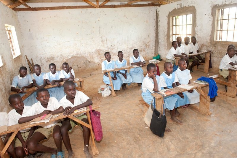 Школа в Кении. Здесь уже и мебель попроще, и с полом в классе беда. Но тут хотя бы есть стены
