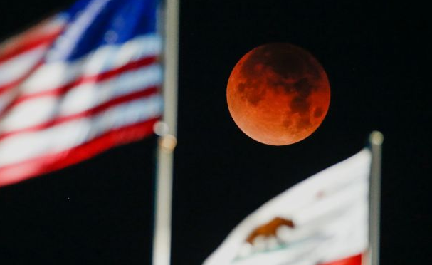 Кровавая Луна над флагами США и Калифорнии на пляже в Санта Монике