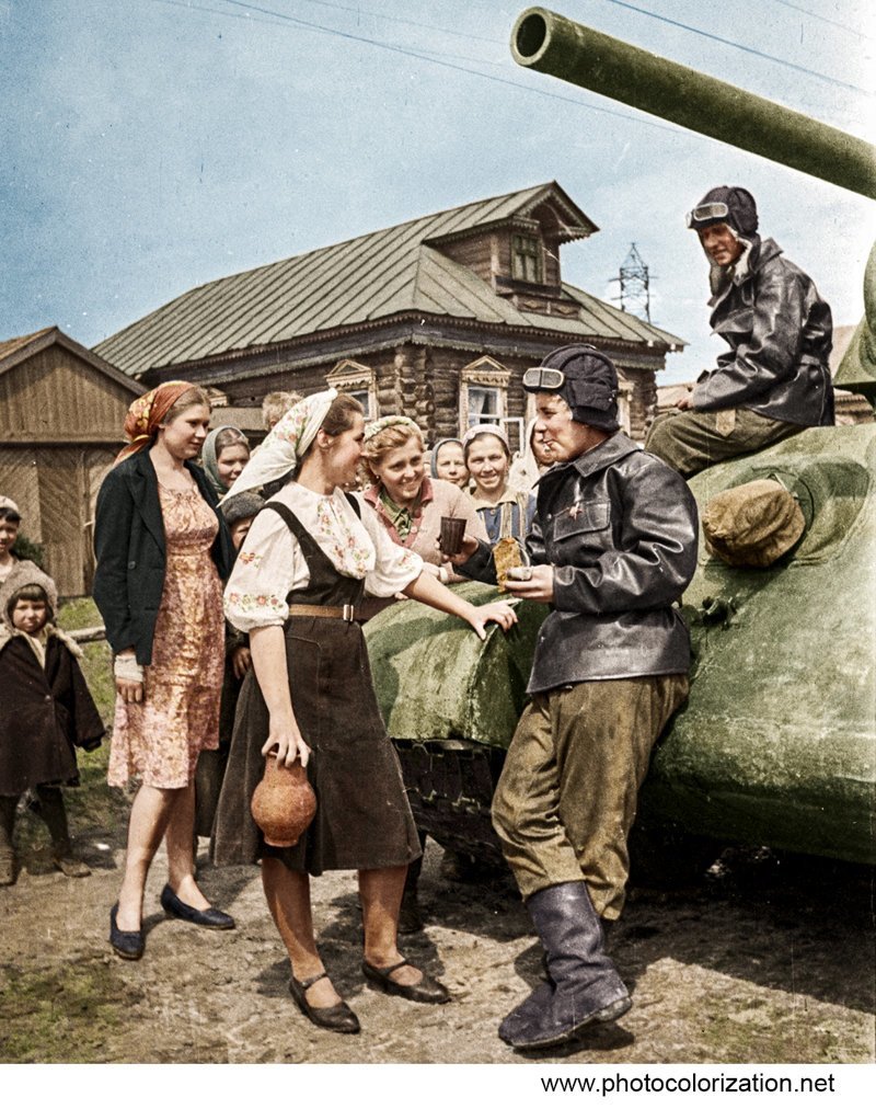 Девушки угощают экипаж советского танка Т-34 на сельской улице