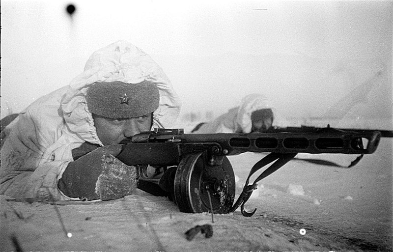 Советские пехотинцы залегшие в заснеженном поле. Ближний солдат вооружен ППШ-41 ранних выпусков с секторным прицелом.
