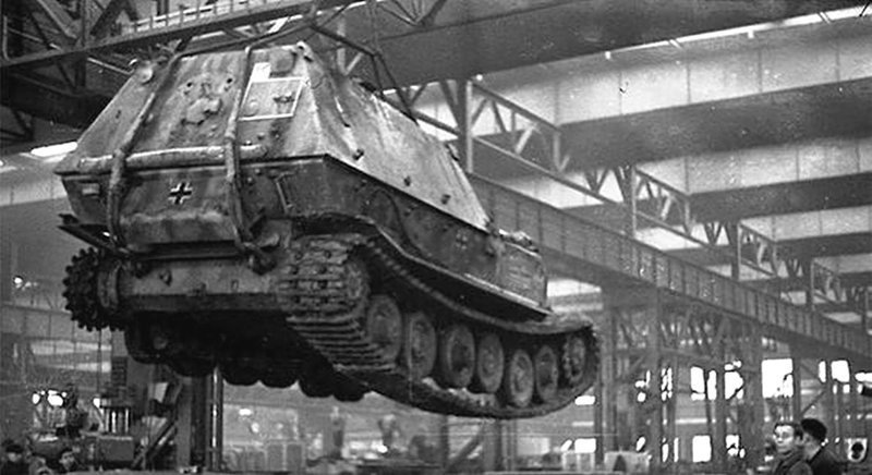 Кран переносит «Фердинанд» к месту работ. Завод «Нибелунгенверке», январь 1944 года. На корме машины видно тактическое обозначение 2-й роты 653-го батальона периода боёв Курск