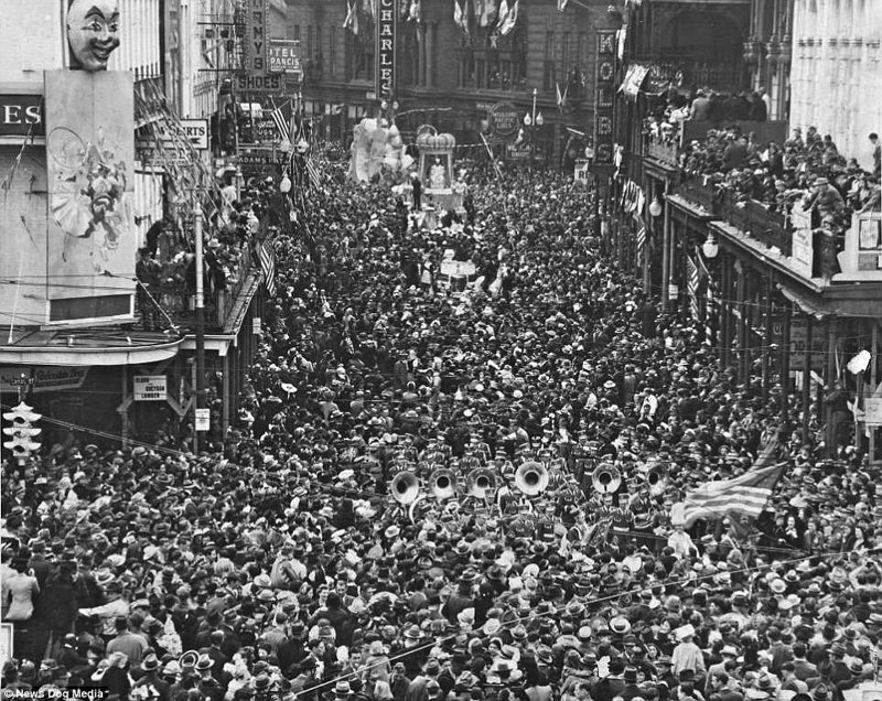 Толпа шествует по улицам города во время знаменитого карнавала "Марди Гра", примерно 1900 год