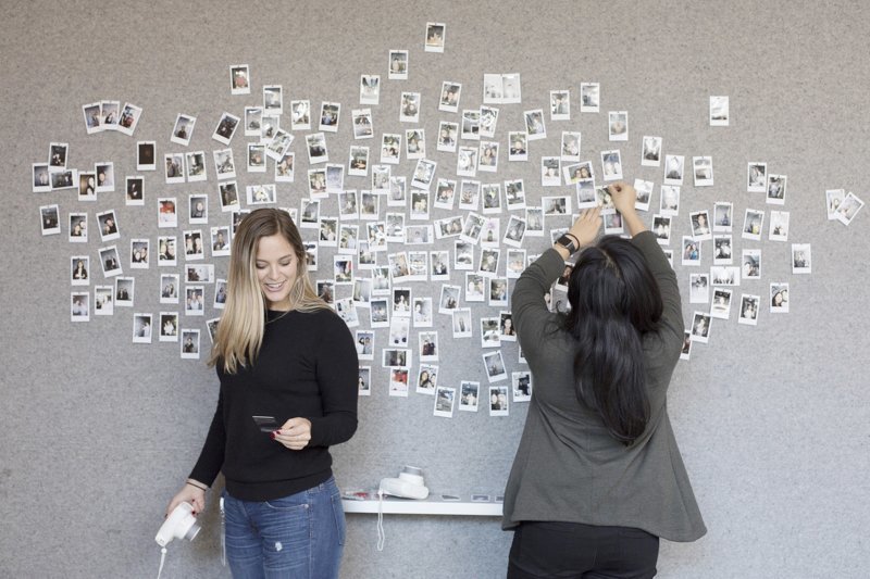 В офисе есть специальная стена, на которую любой гость или сотрудник может прикрепить свое фото. Для этого на столе две камеры Fujifilm Instax, которые снимают в стиле Polaroid 