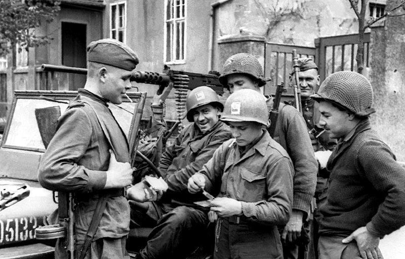 Советские и американские солдаты отдыхают у джипа «Виллис» во время встречи на Эльбе.