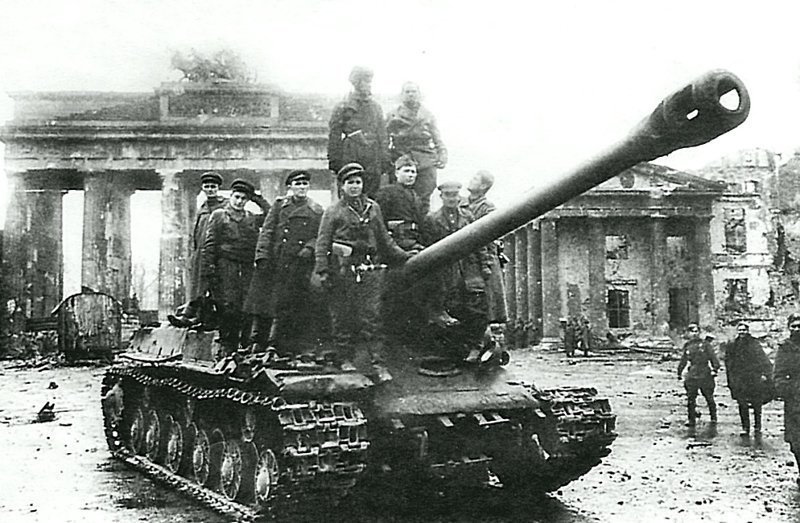 Советские танкисты фотографируются на память на фоне разбитых Бранденбургских ворот в Берлине, стоя на броне тяжелого танка ИС-2.