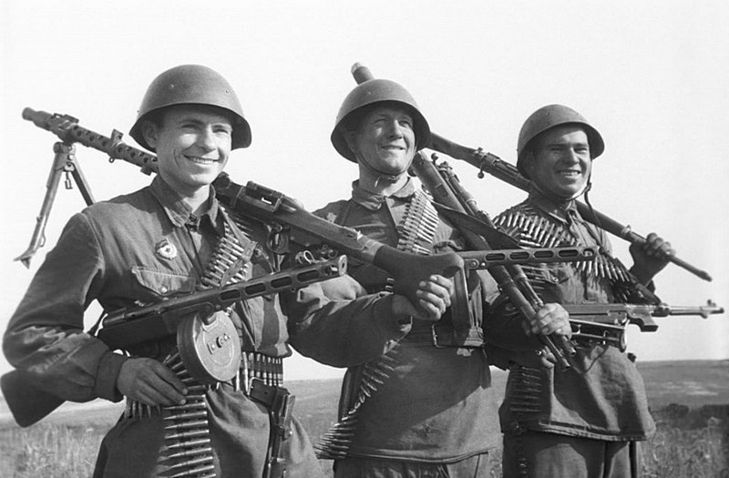Солдаты-гвардейцы с захваченным немецким стрелковым оружием. У бойца слева на плече немецкий пулемет MG-34, в качестве личного оружия двое вооружены пистолетами-пулеметами системы Шпагина (ППШ). У солдата в центре карабины «Маузер», у бойца справа на