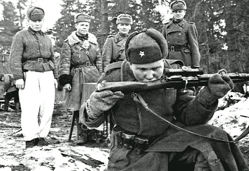 Советский солдат целует снайперскую винтовку Мосина во время церемонии вручения оружия.