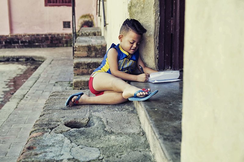 Ребенок рисует на пороге дома