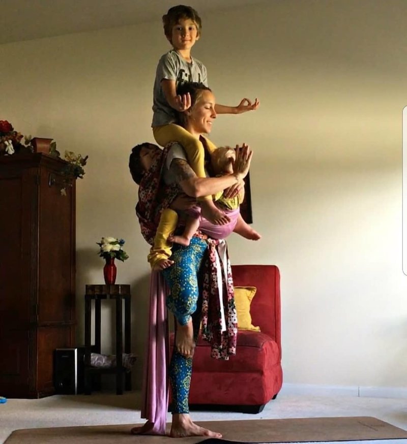Любительница йоги кормит дочь грудью, стоя вверх ногами