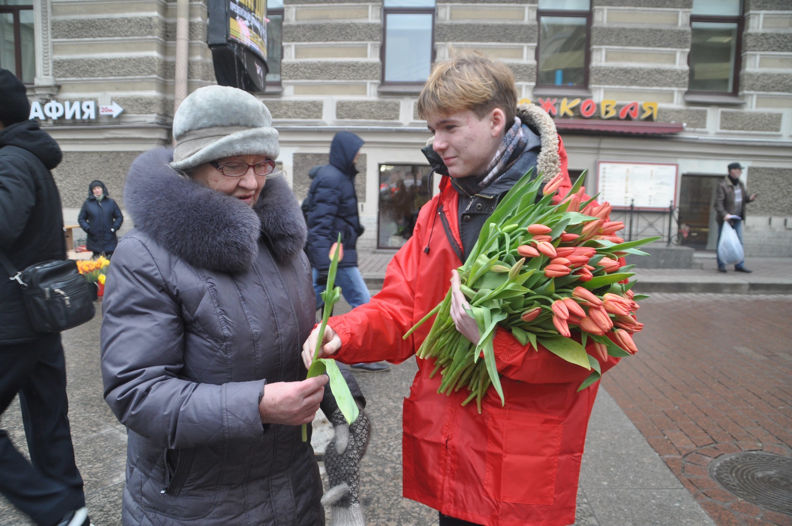 Международный женский день мужчин. Дарят цветы на улице.