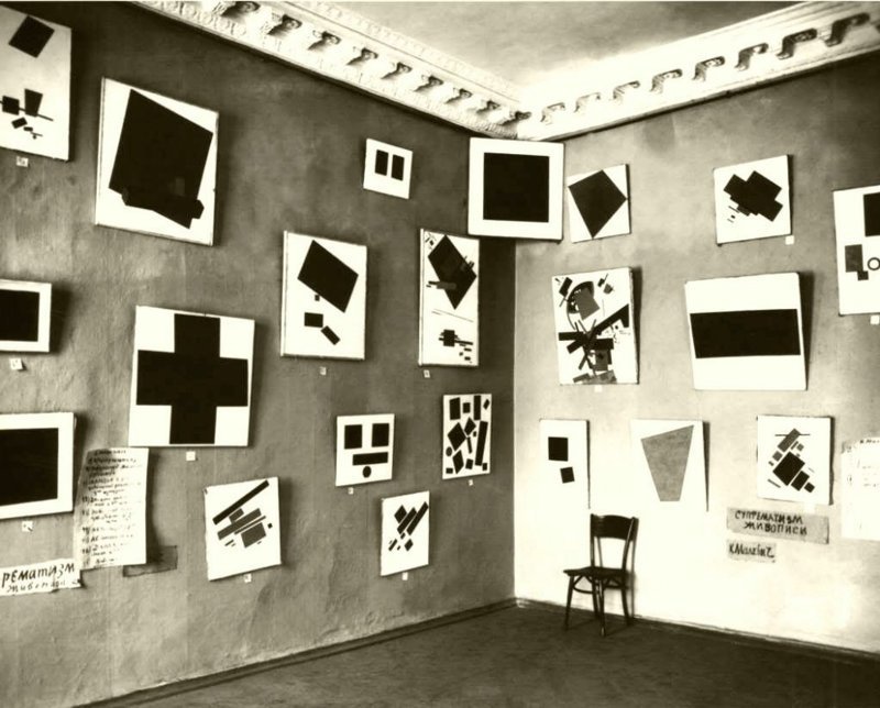 Экспозиция картин Казимира Малевича на выставке «0,10». На сохранившейся фотографии можно видеть 21 работу из 39-ти, включая знаменитый «Чёрный квадрат».
