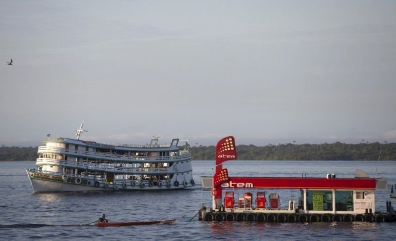 Плавучая заправка Atem для маленьких и средних судов стоит посреди реки Рио Негро, близ порта Панаир, город Манаус, штат Амазонас, Бразилия.