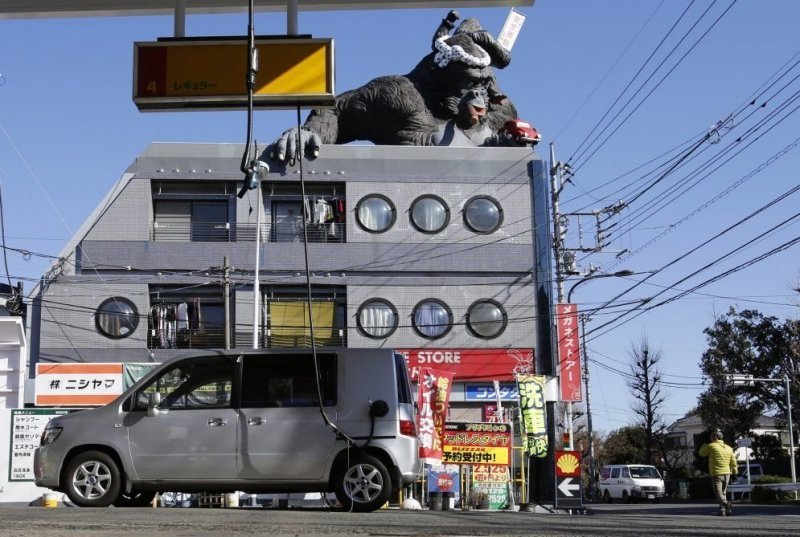 Япония, как всегда отличилась: статую Кинг-Конга на фоне необычной заправочной станции Shell, Токио, Япония.