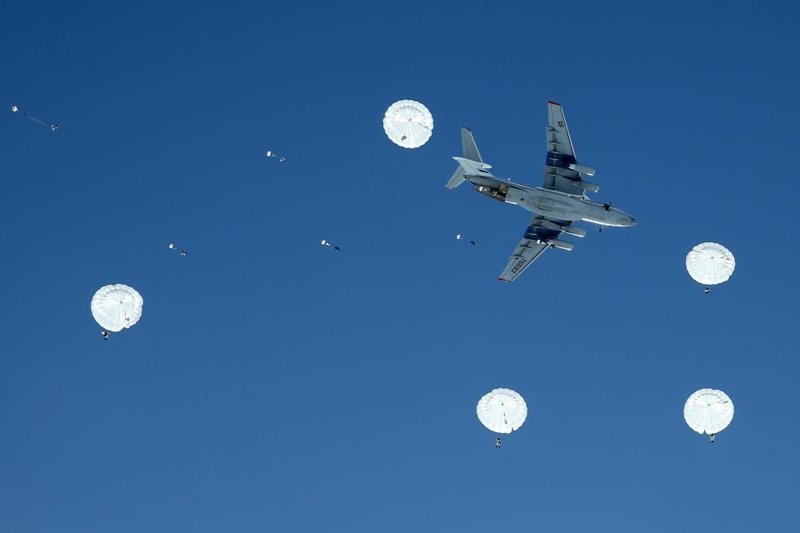 Удивительные и угрожающие фотографии показывают Русских воинов, разбросанных на фоне голубого неба под куполами белых парашютов.