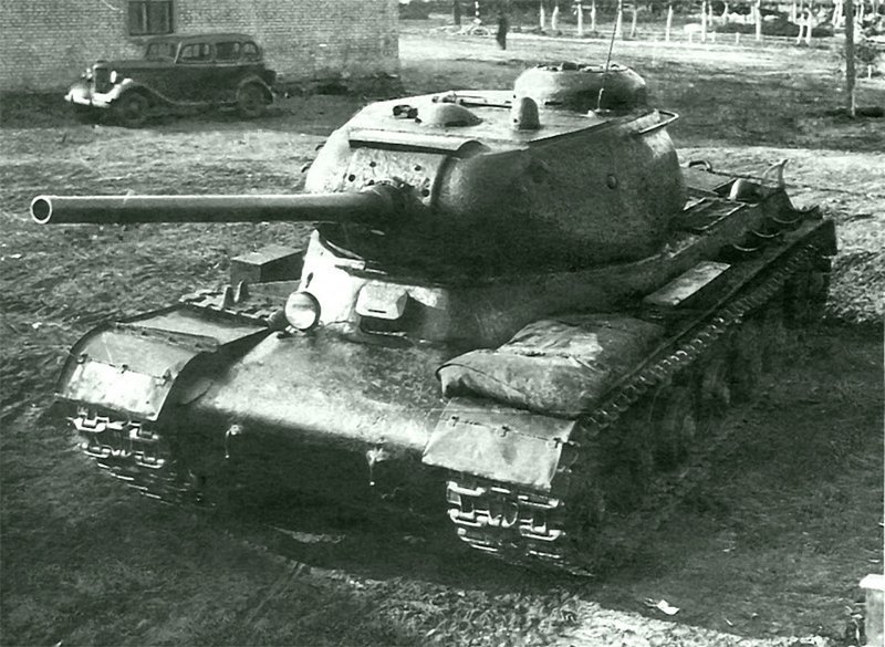 Советский тяжелый танк ИС-1 с пушкой Д5-Т85 L52.0 во дворе Челябинского Кировского завода. На заднем плане автомобиль ГАЗ М1.   Челябинск,  август 1943 