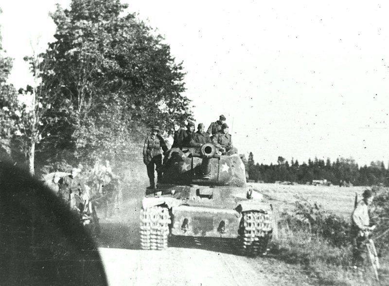 Танк ИС-2 из состава советской колонны движется по дороге на ближних подступах к Таллину. Сентябрь 1944