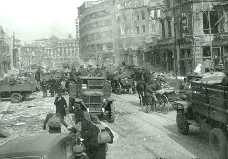 Советские автомобили и немецкие мирные жители на улице Берлина. В центре фото — грузовой автомобиль ЗиС-5В. Время съемки: май 1945. 
