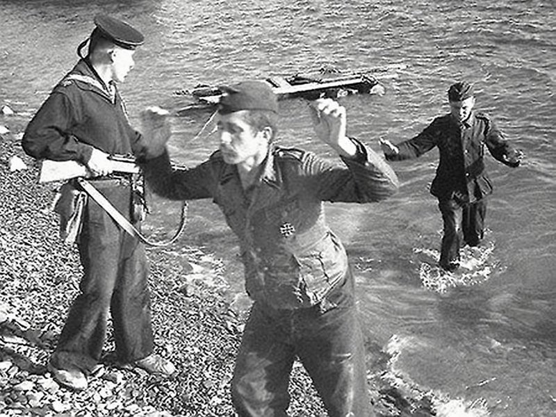 Советский морпех выуживает из воды пленных немцев.