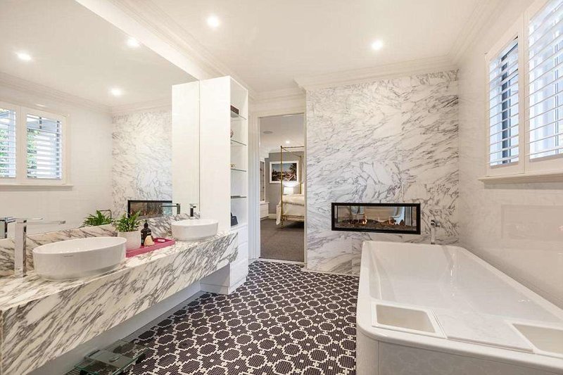 Весь дом наполнен неожиданными дизайнерскими решениями. Ниже - камин, встроенный в стену между спальней и ванной комнатой.