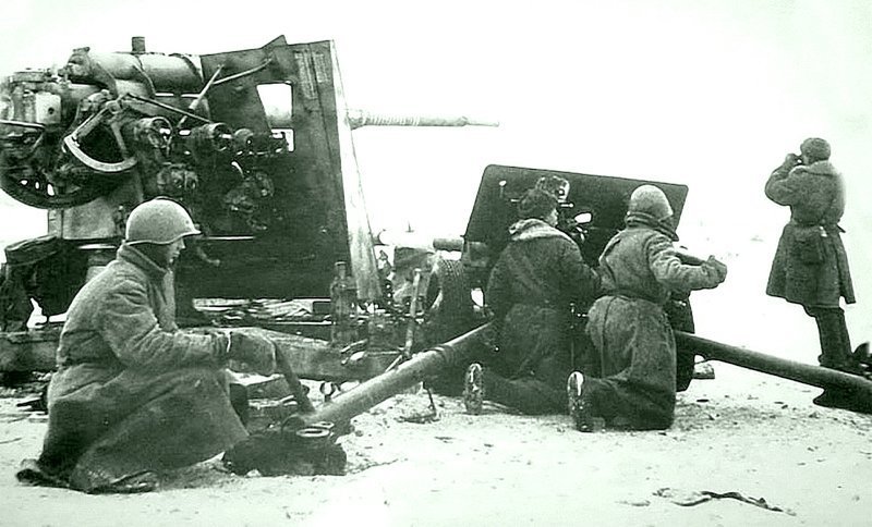 Артиллеристы расчёта 76,2-мм дивизионной пушки обр. 1942 г. (ЗИС-3) Ленинградского фронта на огневой позиции у подбитого немецкого 88-мм зенитного орудия 8.8 cm Flak 37. Ведут огонь прямой наводкой по немецким укреплениям в районе Ропши.