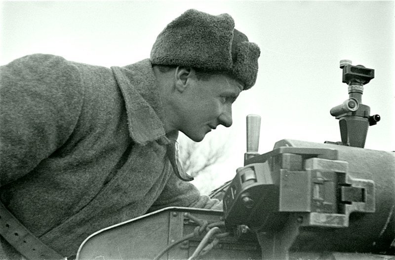 Советский солдат-артиллерист производит наведение 76-мм полковой пушки образца 1927 года. Наведение орудия производилось посредством артиллерийской панорамы ПГ-1 (панорама Герца). Автор: Семен Фридлянд. 