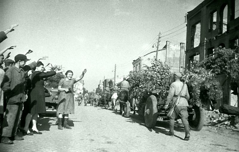 Жители освобожденного Белостока приветствуют колонну советских артиллеристов со 122-мм гаубицами образца 1938 года М-30. В конце сентября 1944 года Белосток был включен в состав Польши. Место съемки: Белосток, Белоруссия,  Время съемки: июль 1944.