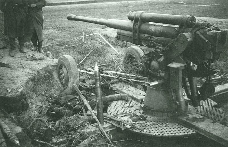 Установленное на прямую наводку разбитое советское зенитное 85-мм зенитное орудие 52-К и погибший артиллерист в Литве.