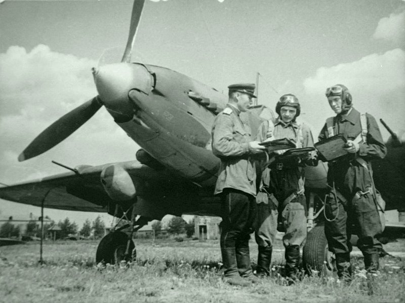 23. Советские летчики возле штурмовика Ил-2 обсуждают боевое задание.