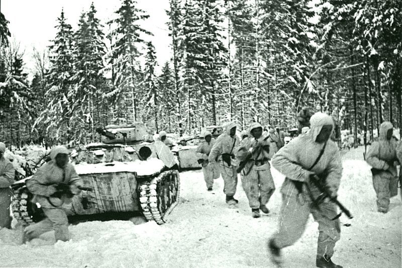 Танковый десант одной из частей 1-й Гвардейской мотострелковой Московской дивизии и колонна легких танков Т-40 в зимнем лесу во время битвы за Москву. декабрь 1941.  